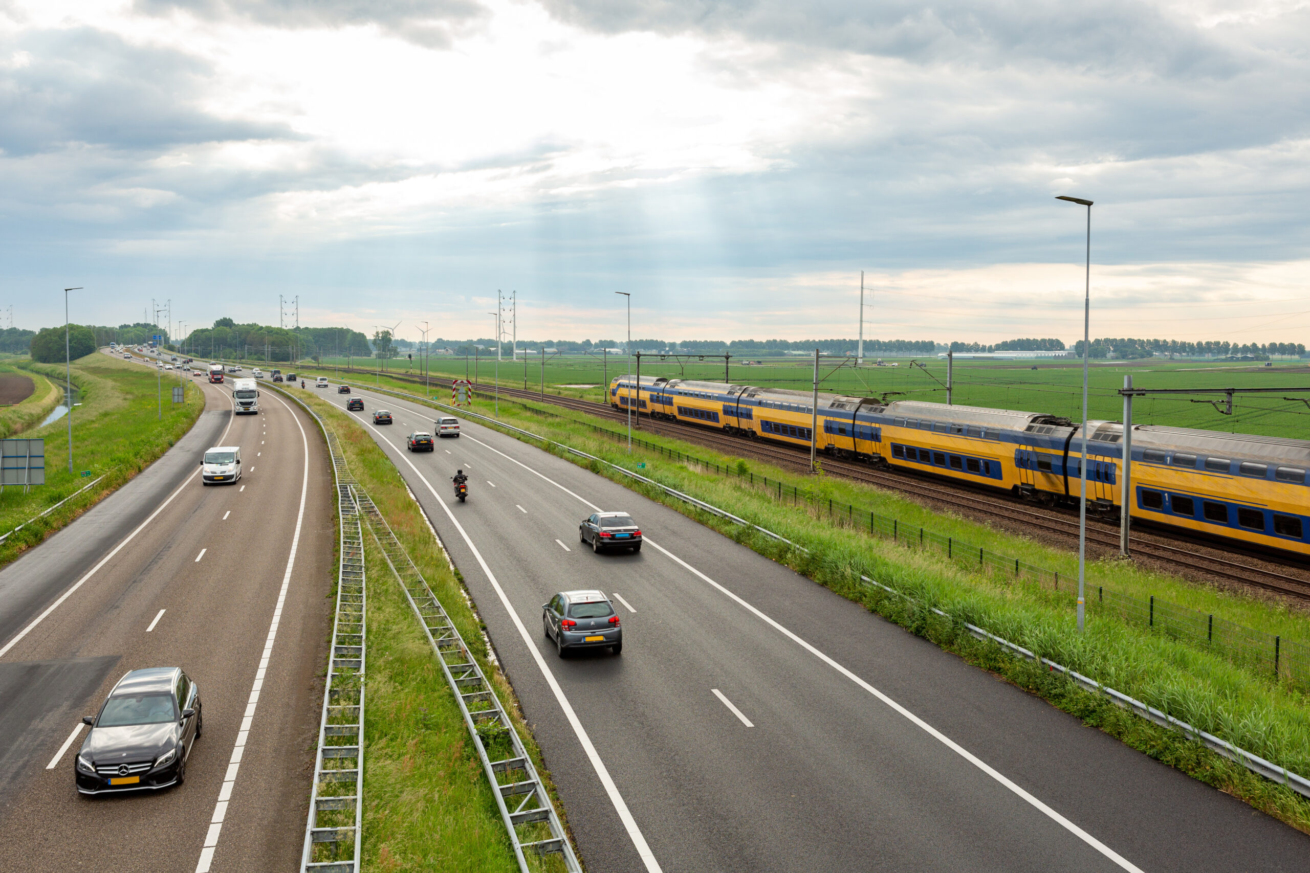 Cars on the A44 highway and a train near the village of Abbenes in the Netherlands.